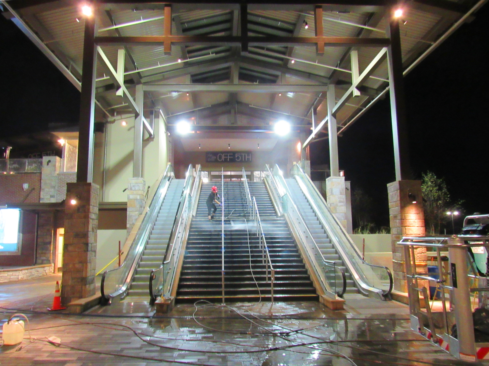 Expert pressure washing shopping center with stairs at night