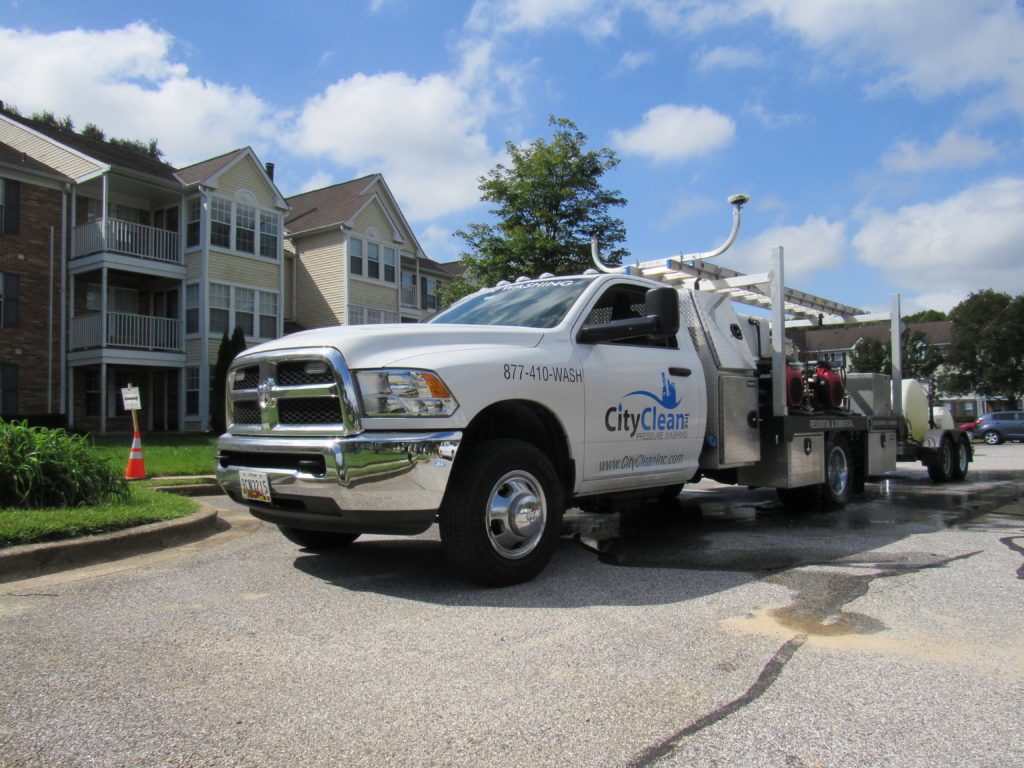 City Clean truck with professional power washing machines outside residential community