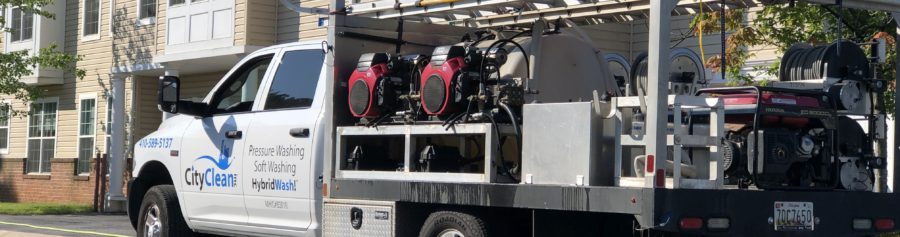 City Clean truck with power washing equipment in front of residential community