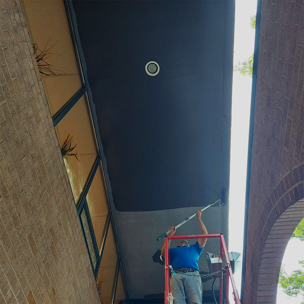 Painter painting ceiling outside of an office building in Baltimore Maryland